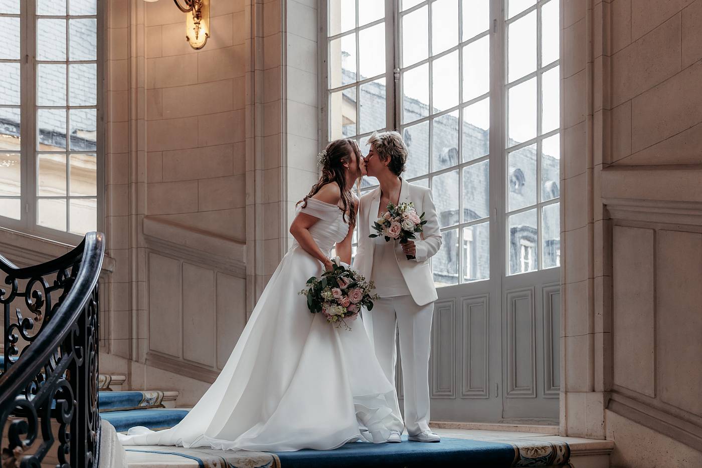 Baiser échangé par les mariées dans les marches de la mairie de Versailles