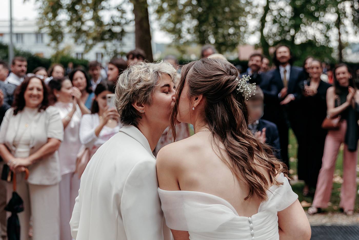 Les mariées s'embrassent devant leurs invités