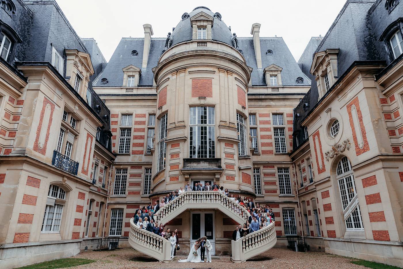 Une photo de groupe avec la façade arrière de la mairie de Versailles