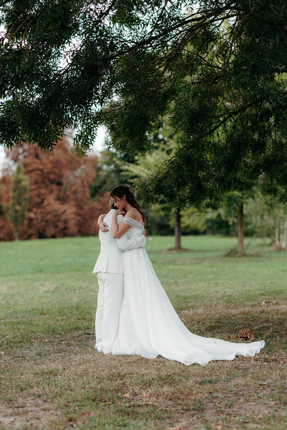 Portrait plein pied des mariées sous les branches d'un arbre