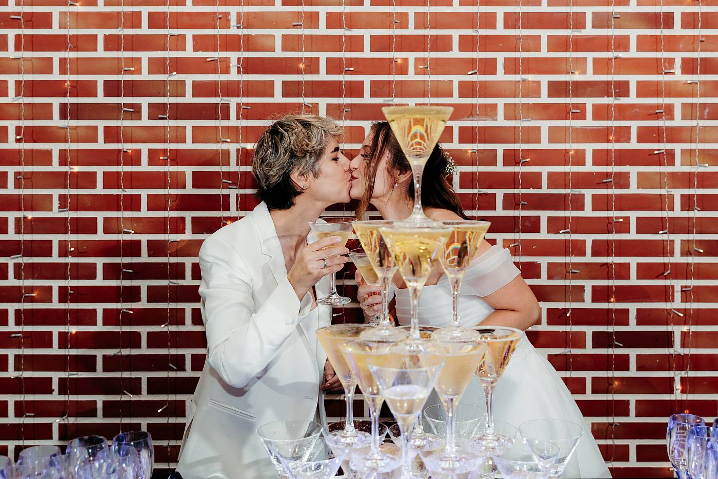 Le baiser des mariées avec une coupe de champagne en main