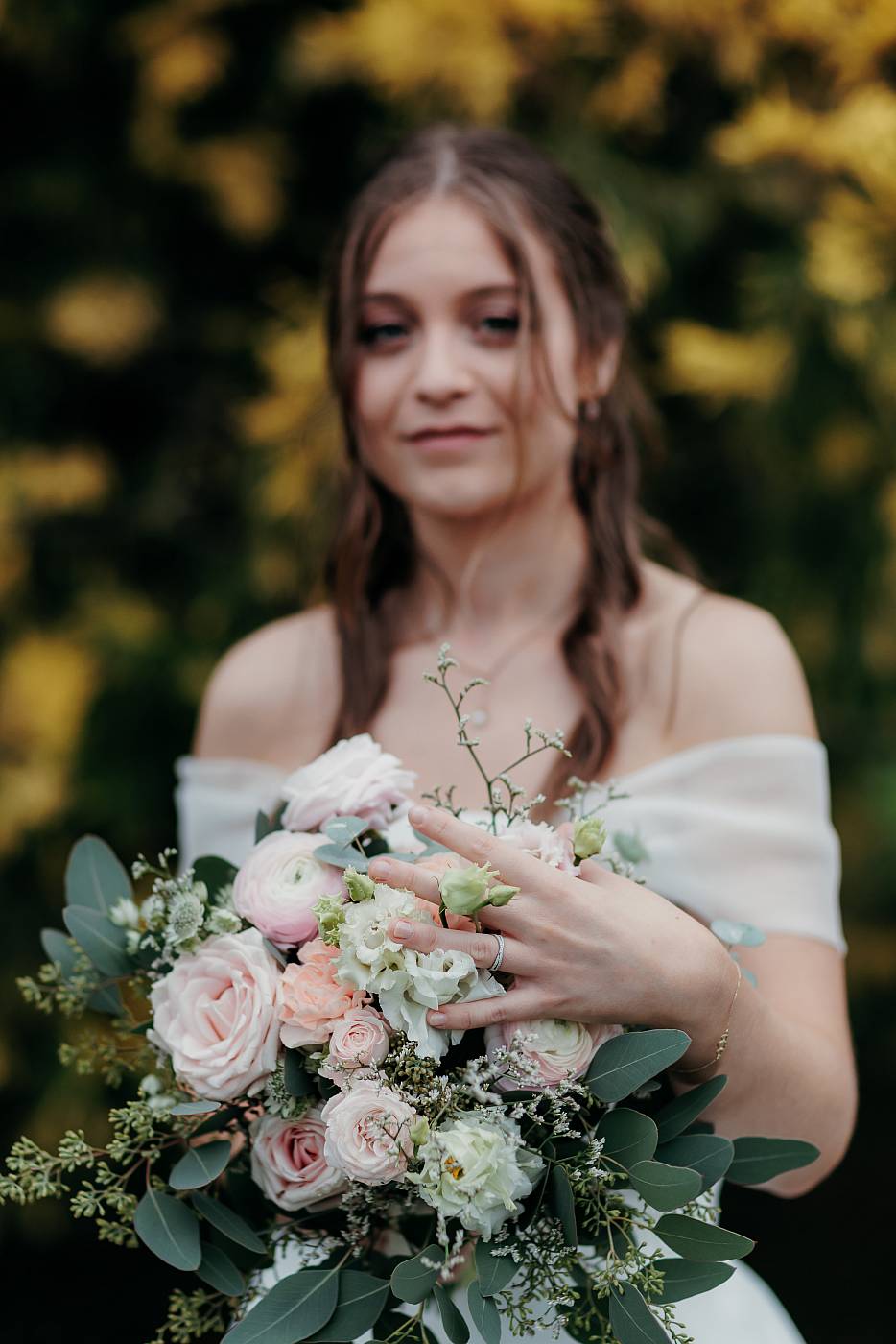 Portrait de la mariée avec l'alliance et son bouquet