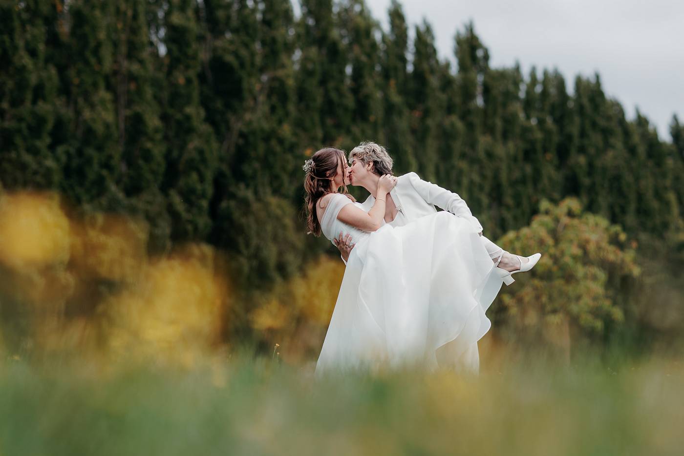 Pose classique des mariées parmi les fleurs jaunes