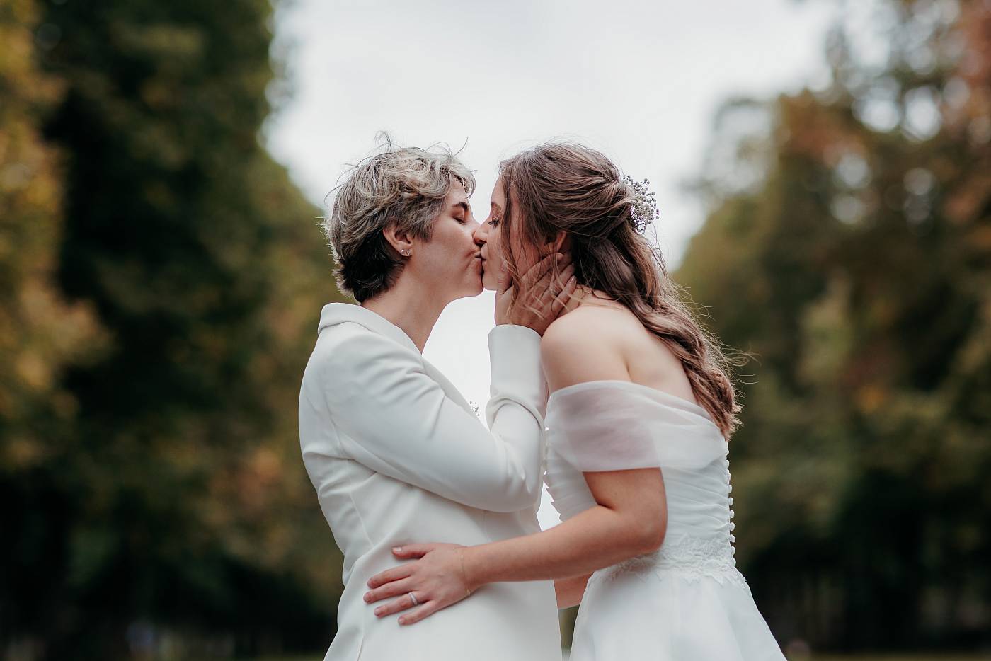 Le baiser des mariées avec la belle perspectives des arbres
