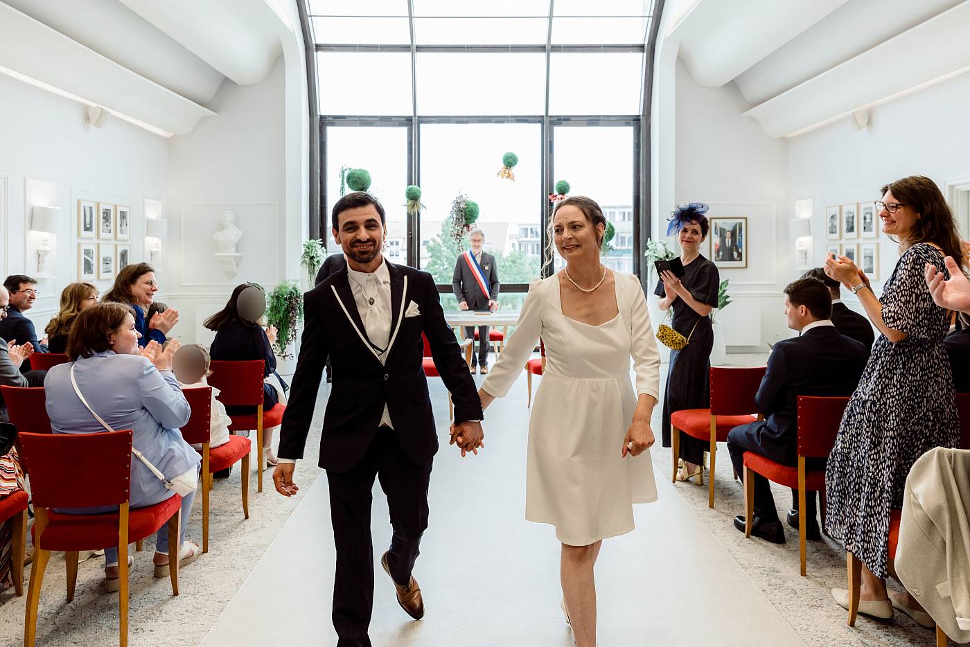 Les mariés quittent la salle des mariages main dans la main