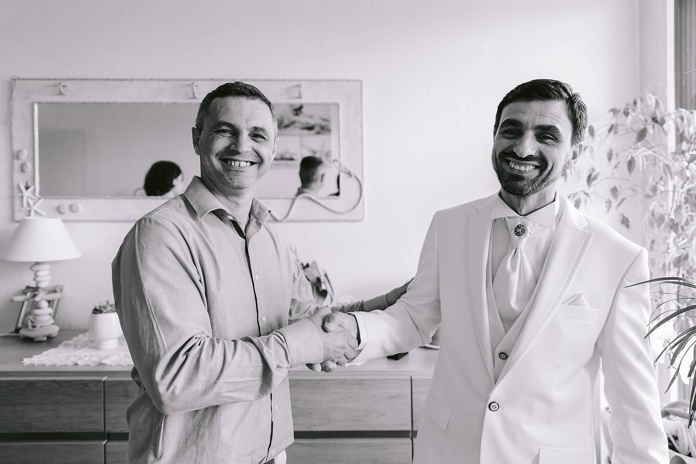 Le marié et son ami échangent une poignée de main avec un grand sourire