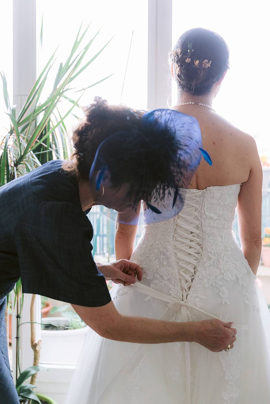 La mère de la mariée lasse la robe de mariage de sa fille