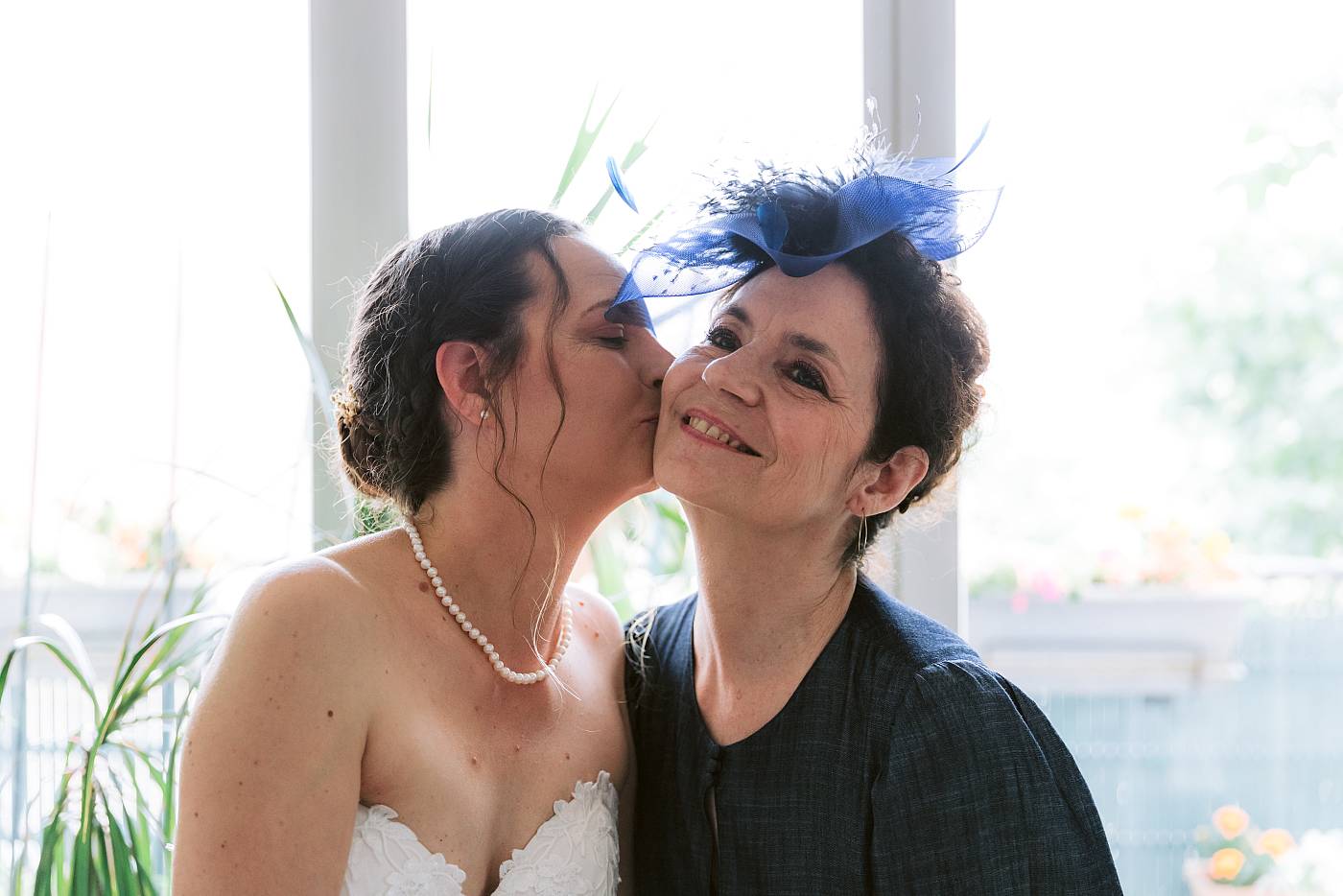 La mariée dépose un baiser sur la joue de sa mère