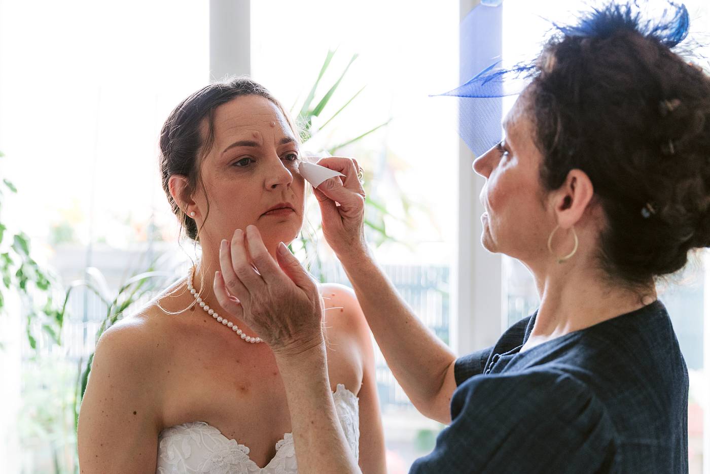 Dernière touche de maquillage sur le visage de la mariée