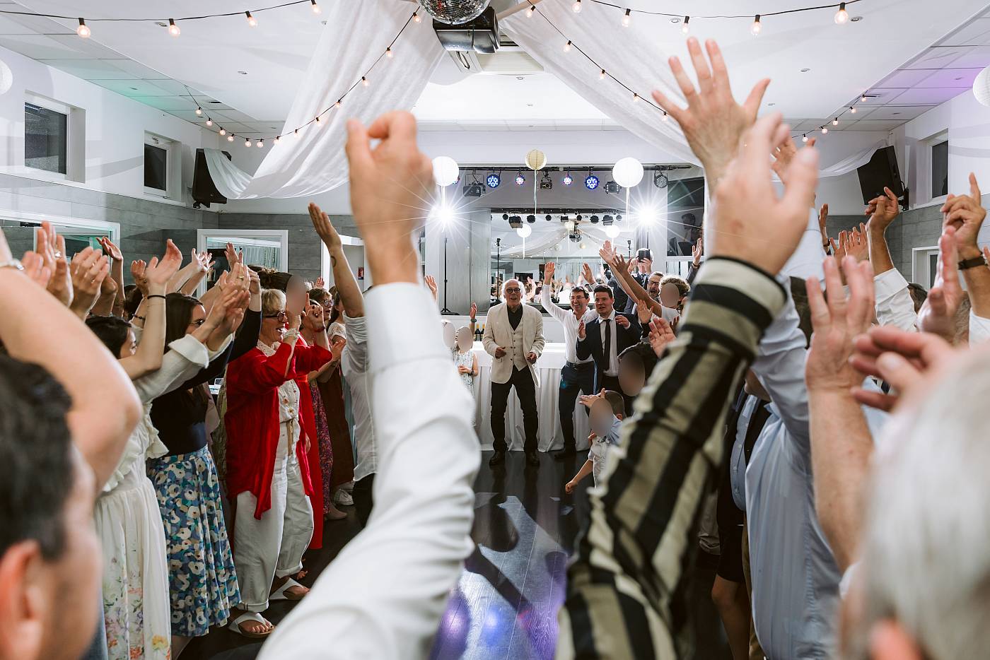 Tout les invités lèvent les mains lors de la soirée dansante