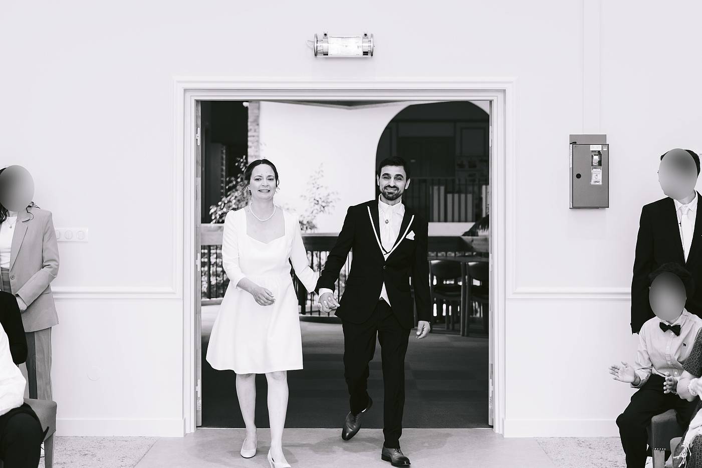 Les mariés arrivent main dans la main dans la salle des mariages