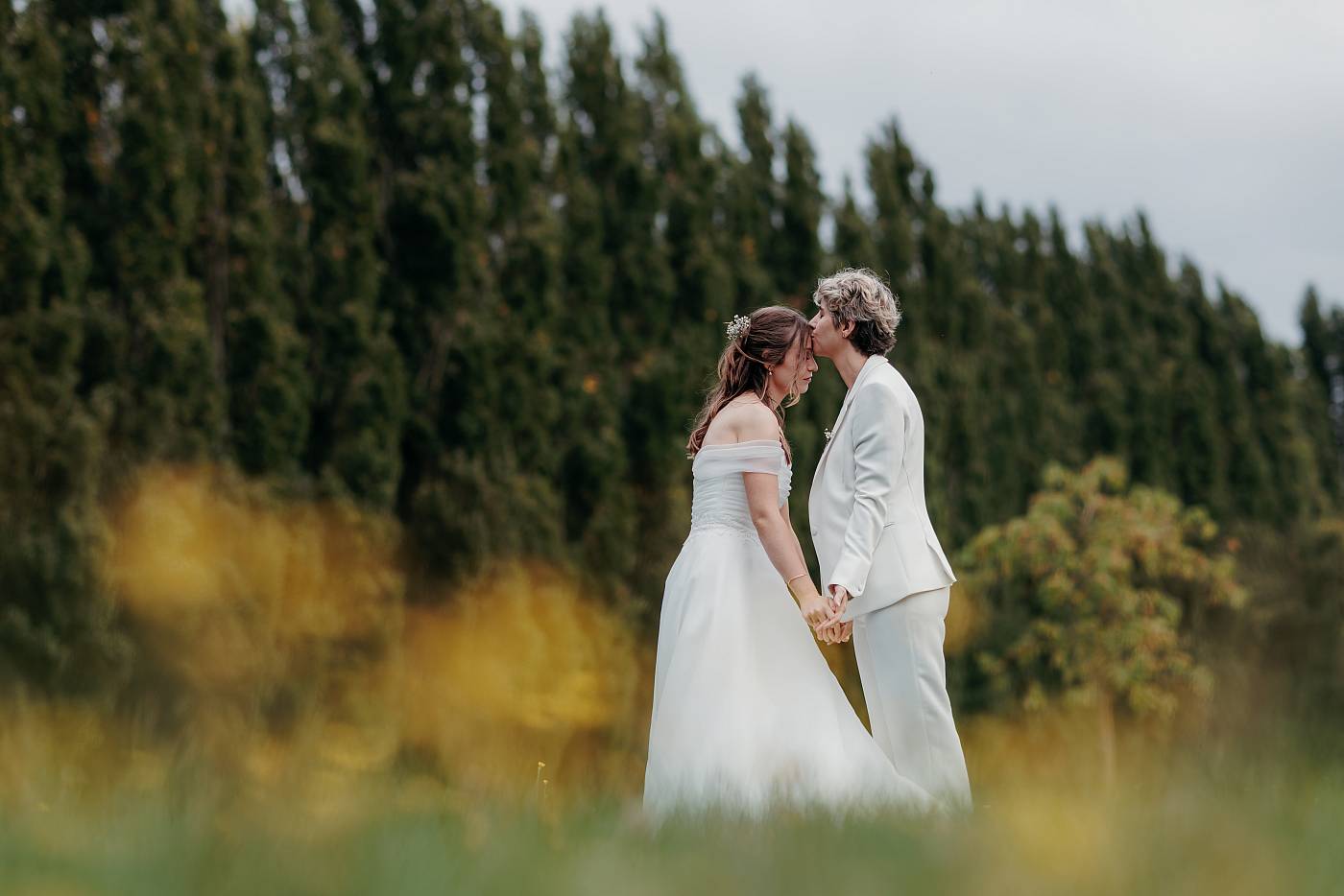 La mariée embrasse l'autre mariée sur le front