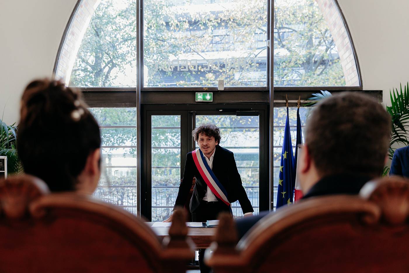 Les mariés vus de dos devant le maire