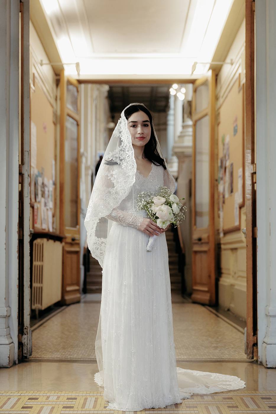 La mariée pose avec son bouquet dans la mairie du 18e arrondissement