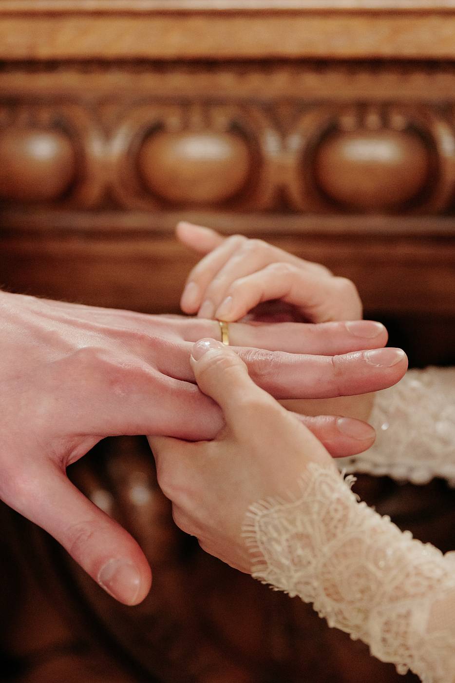 Gros plan sur la mariée qui glisse l'alliance au doigt du marié