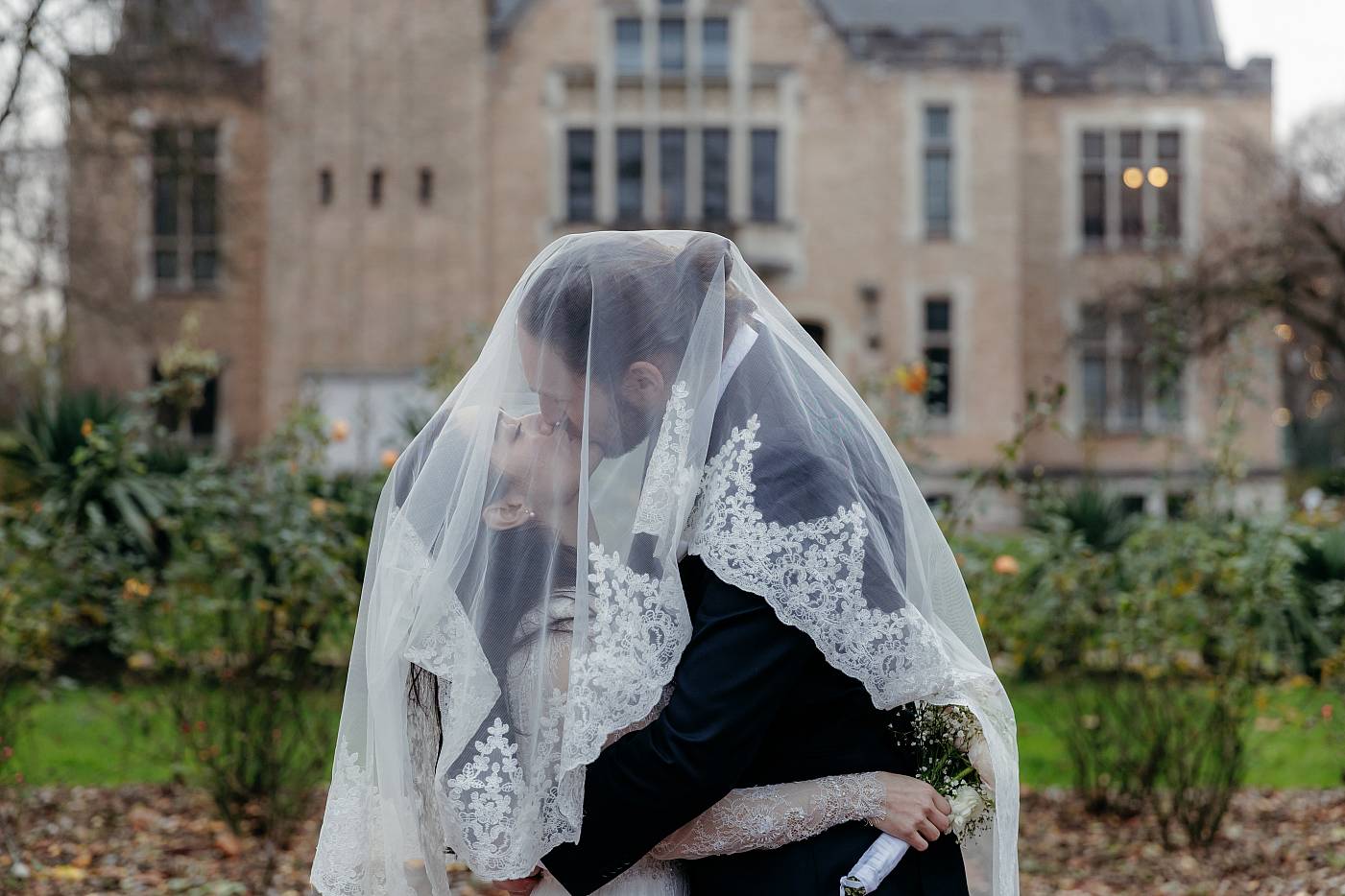 Baiser des mariés sous le voile de la mariée