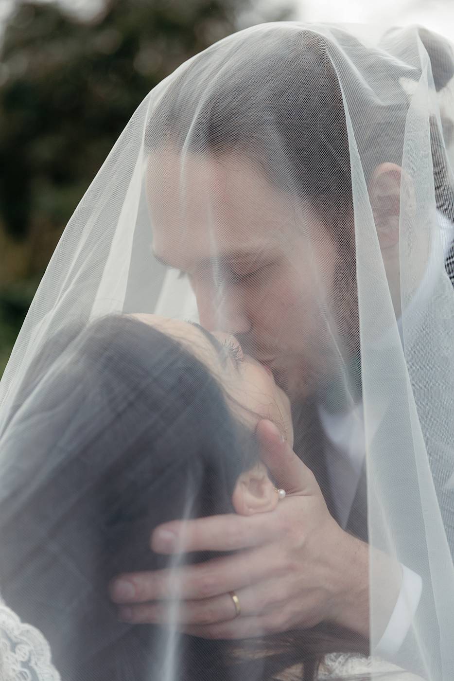 Baiser rempli de tendresse sous le voile de la mariée