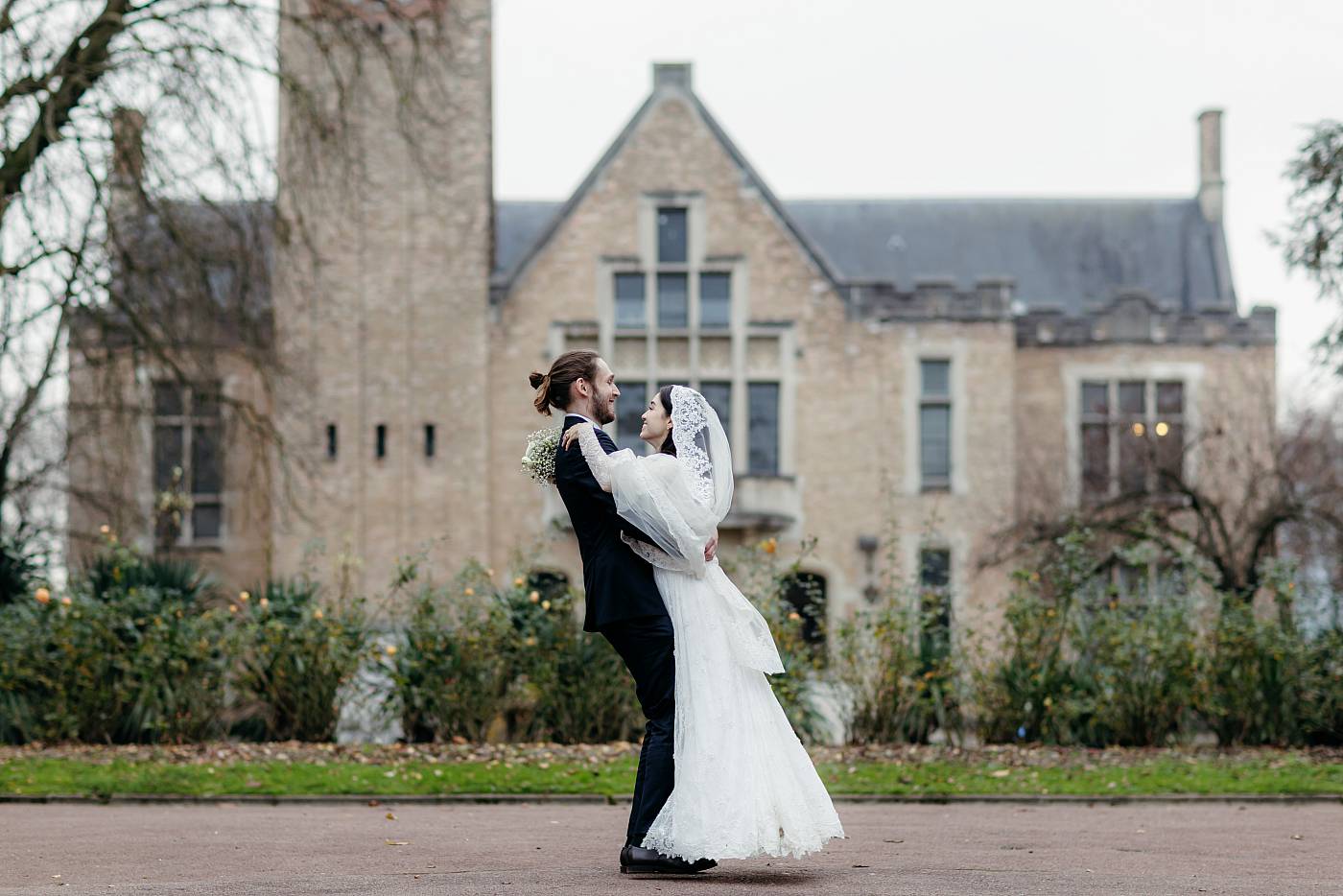 Le marié fait tourner la mariée dans ses bras à la cité universitaire