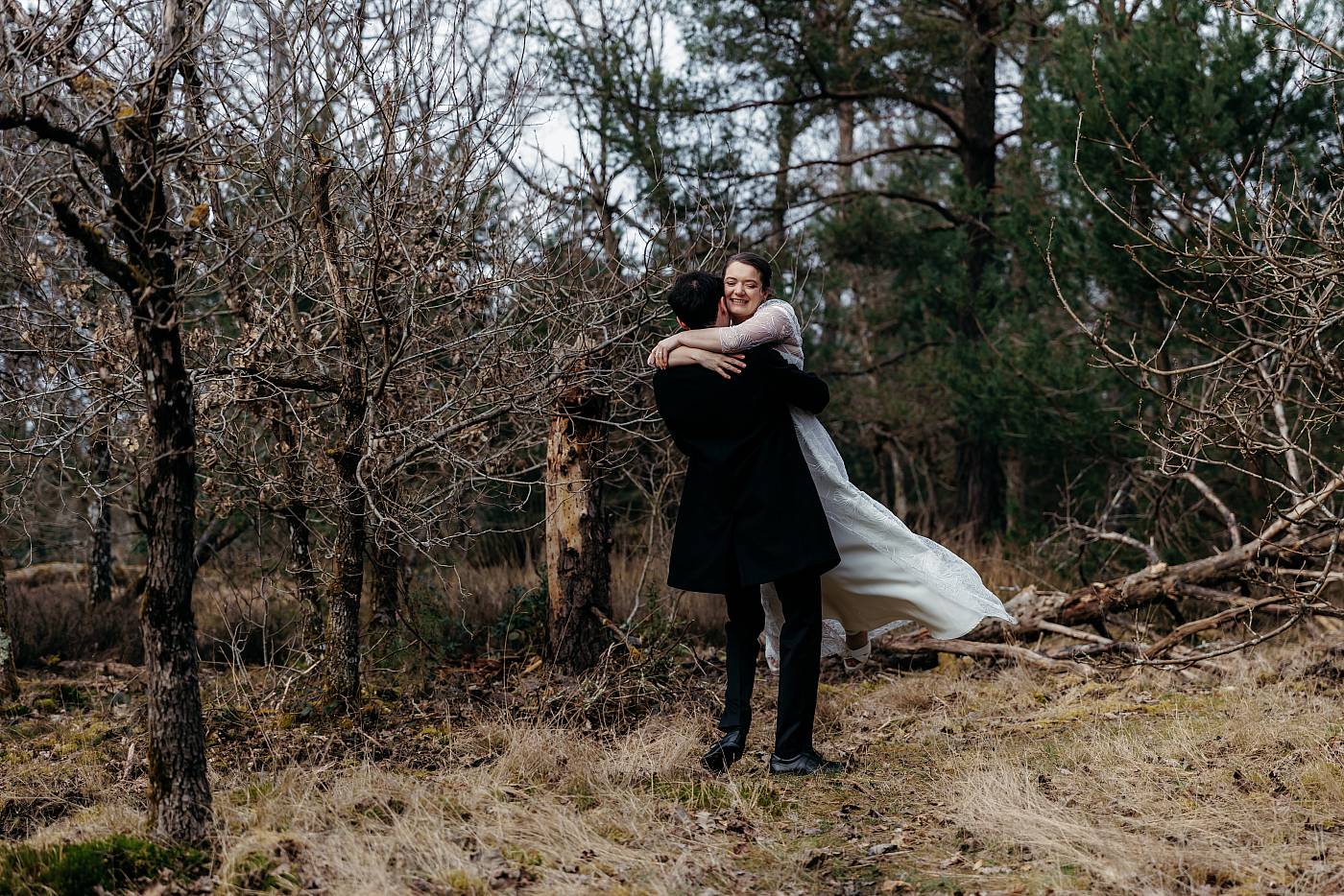 Le marié fait tourner la mariée dans ses bras dans la forêt de Fontainebleau