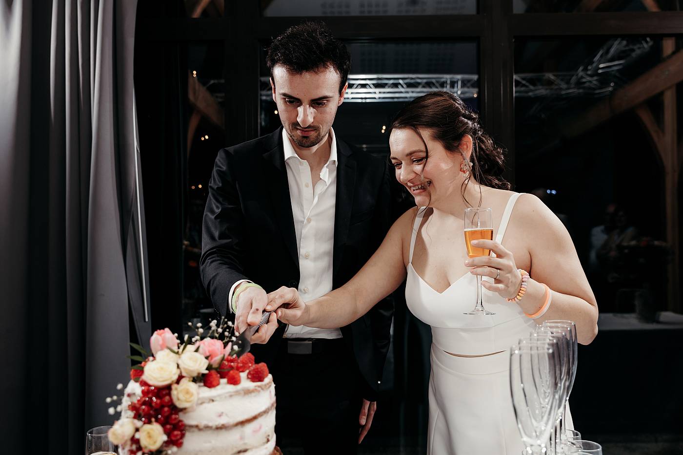 La mariée se joint au marié pour découper la pièce montée
