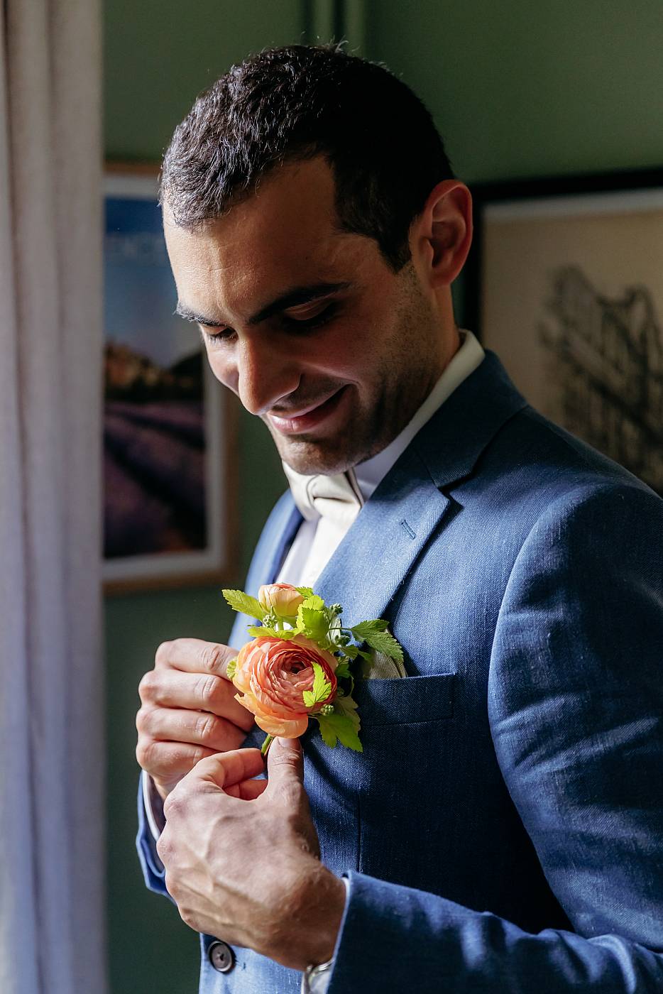 Le marié accroche la fleur à la poche de son costume