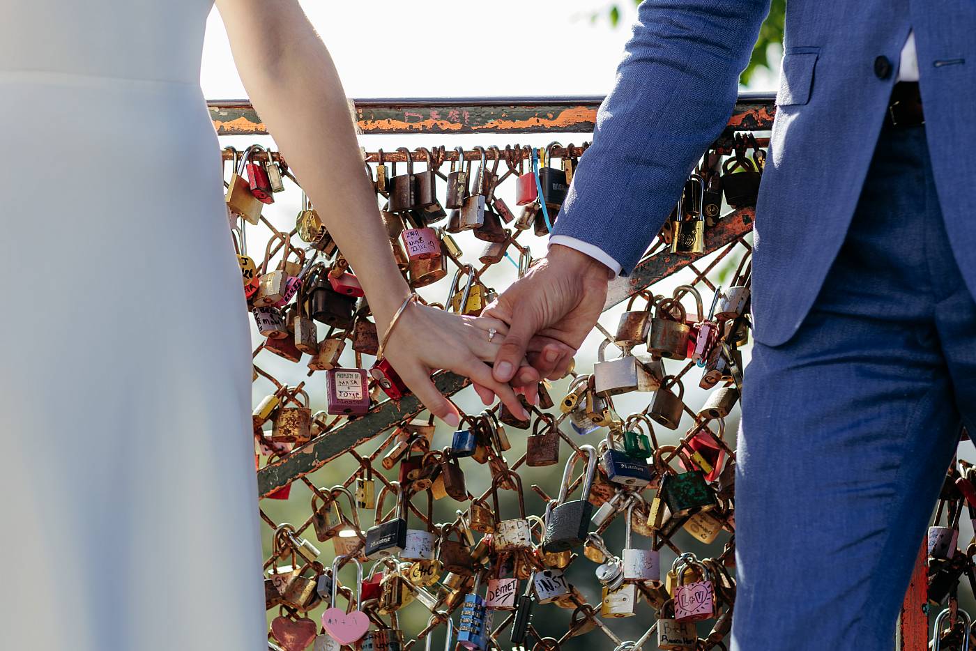 Les mariés se tiennent main dans la main devant les cadenas de Montmartre