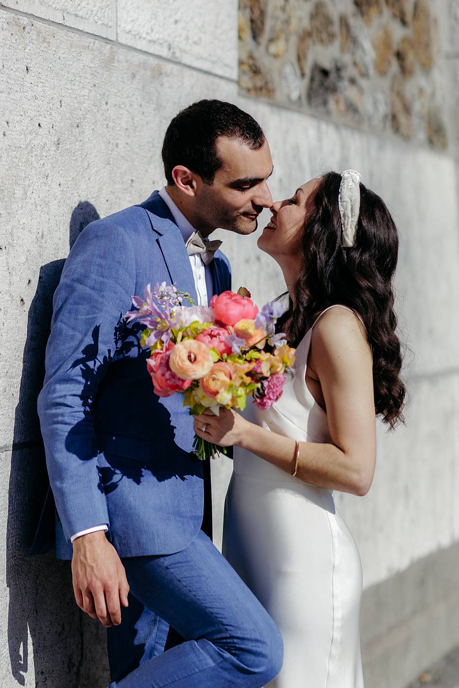 Le marié adossé au réservoir de Montmartre embrasse la mariée