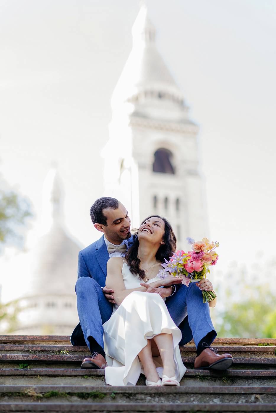 Les mariés jouant au jeu des bisous avec le Sacré-Cœur en arrière-plan
