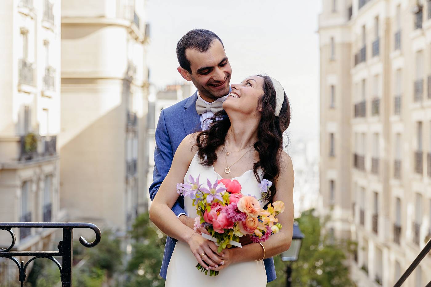Les mariés dans les bras l'un de l'autre dans les escaliers de Montmartre