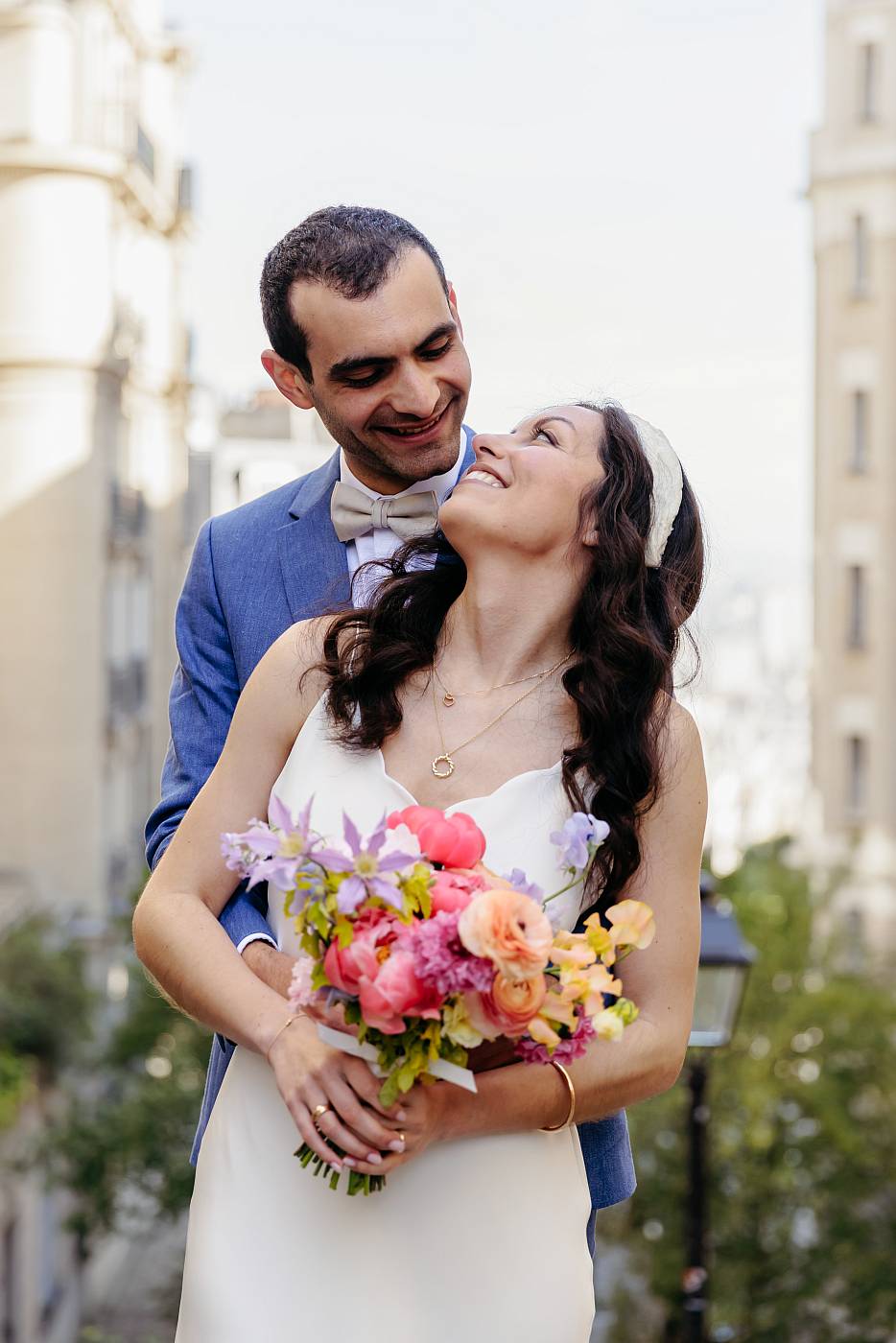 La mariée regarde, amoureusement le marié dans les escaliers de Montmartre