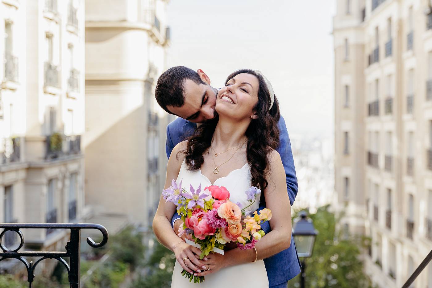 Baiser dans le cou de la mariée dans les escaliers de Montmartre
