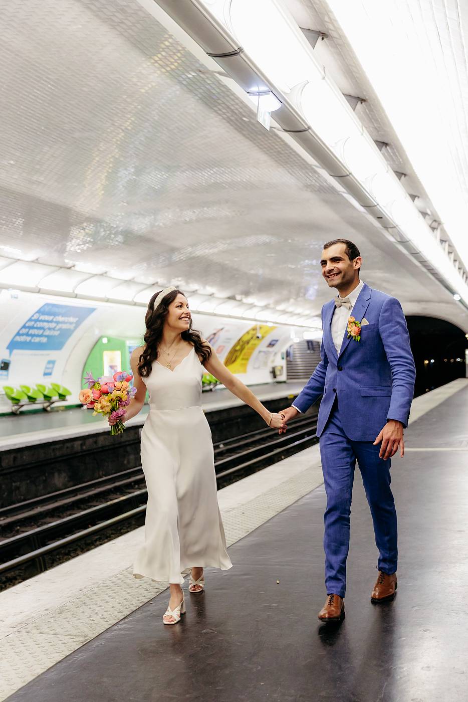 Les mariés main dans la main sur le quai du métro