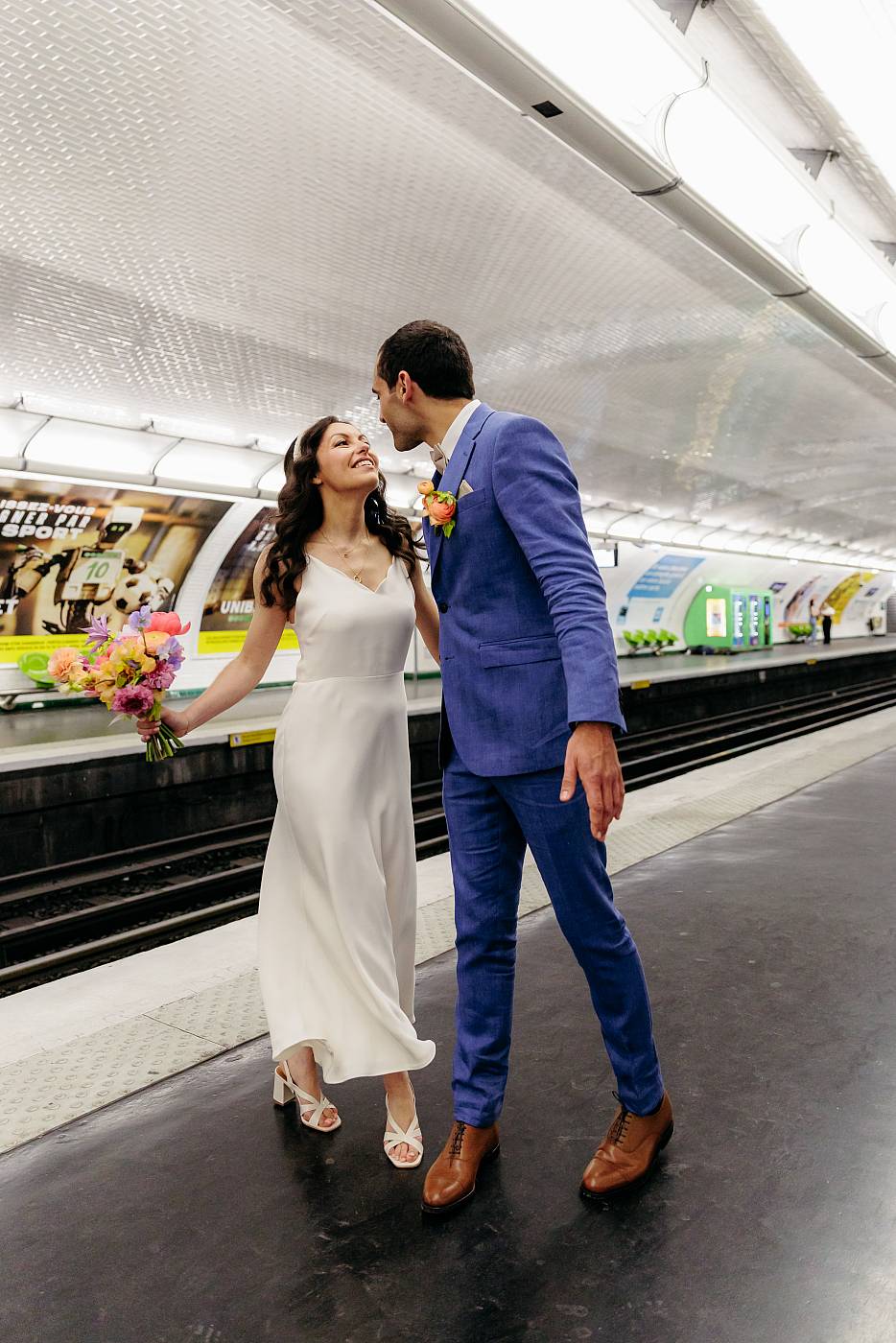 Les mariés prêts à s'embrasser sur le sur le quai du métro