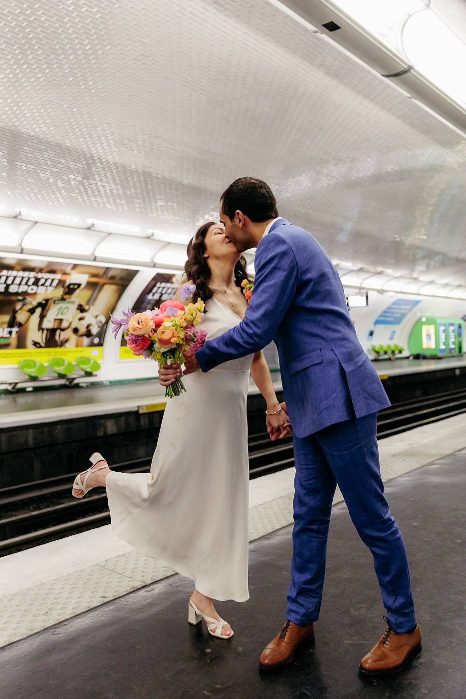 Baiser fougueux des mariés sur le quai du métro