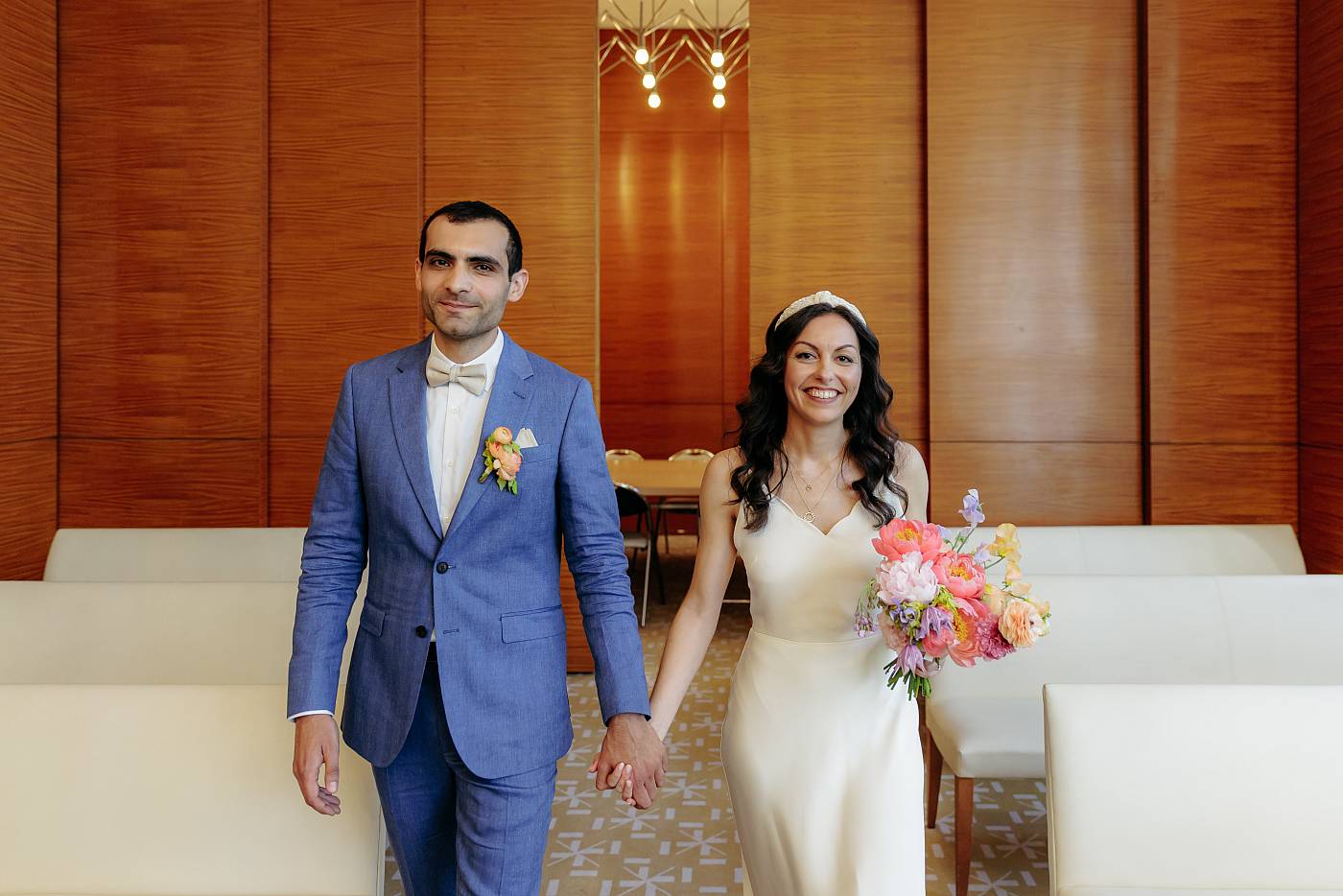 Les mariés marchant en main dans la main dans la salle des mariages