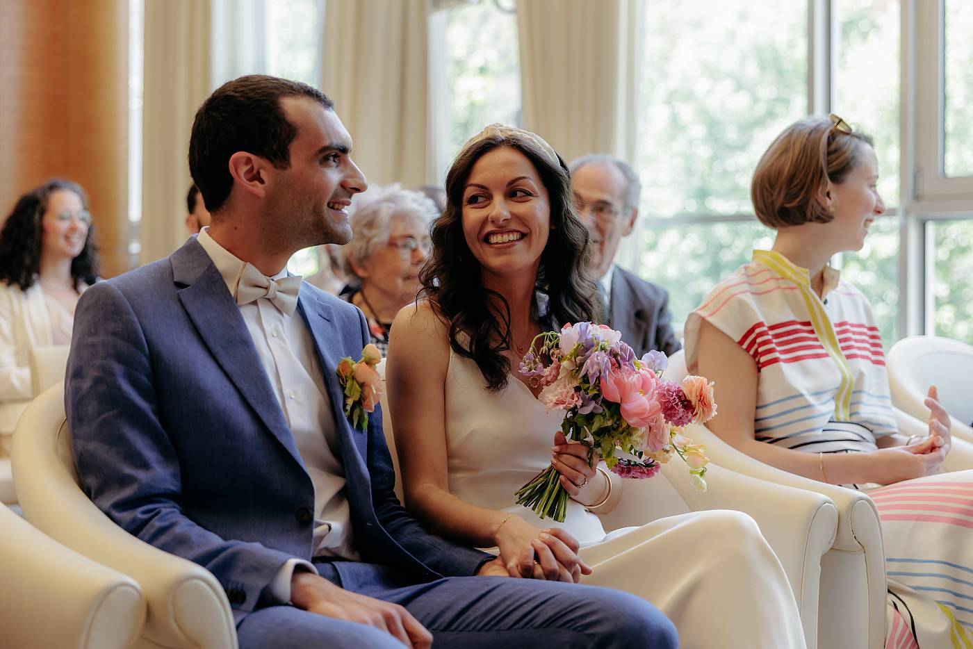 Les mariés prennent place sur les chaises d'honneur de la salle des mariages
