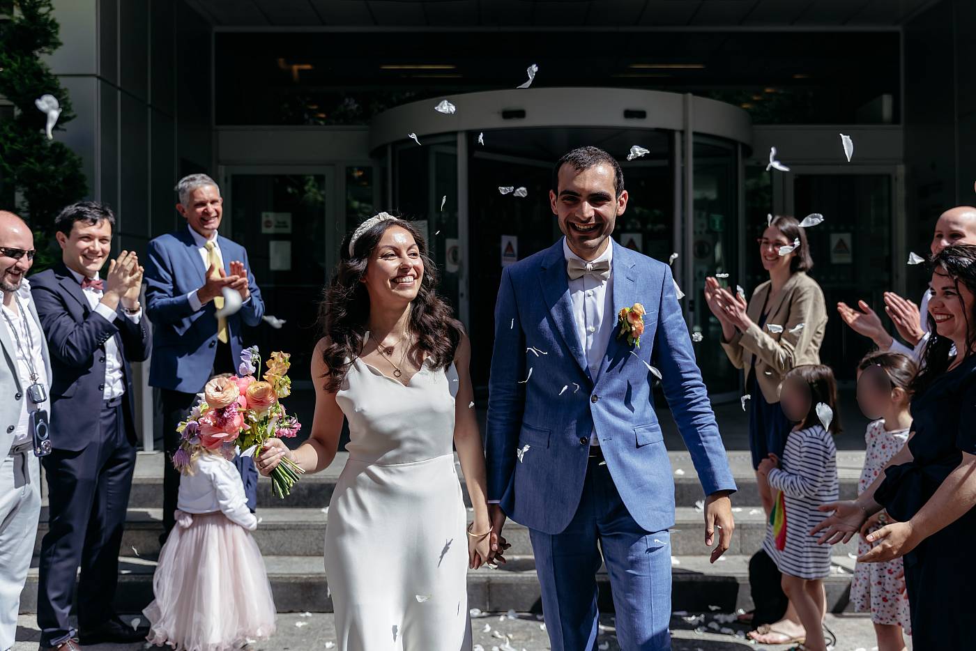 Les mariés tout sourire tandis que les fleurs sont jetées
