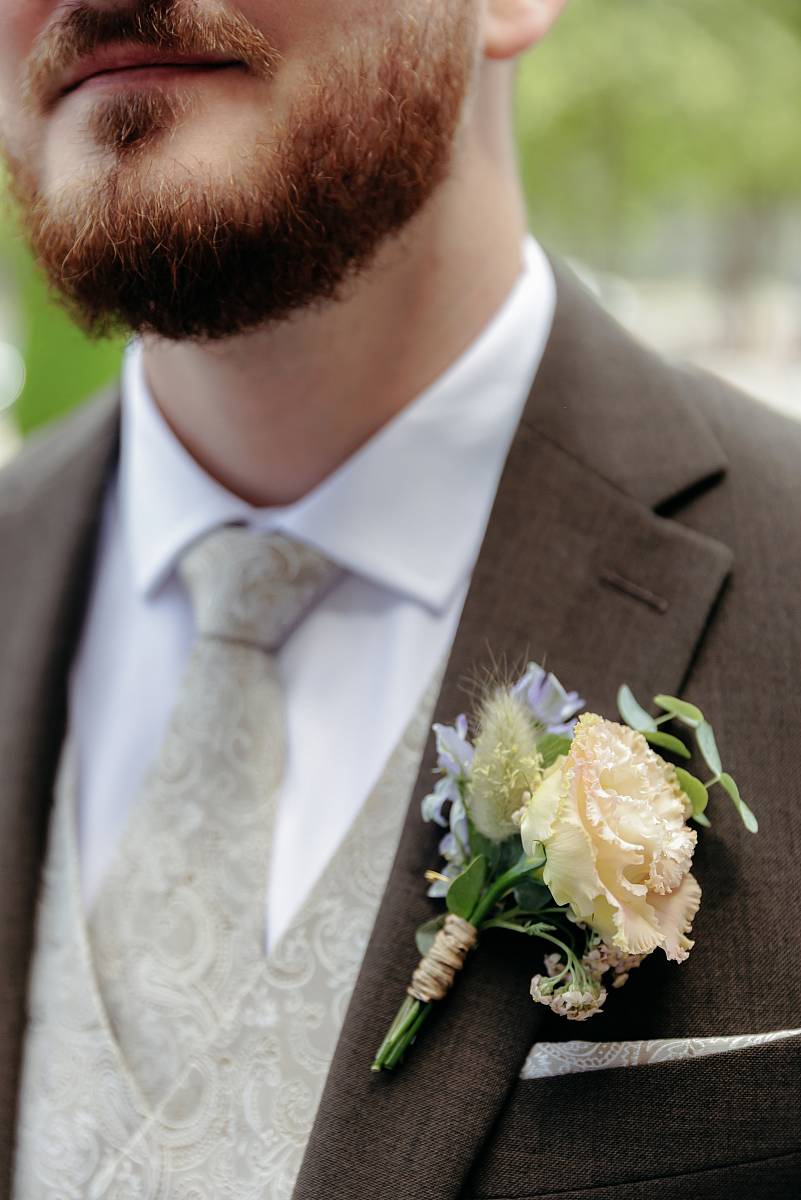 Les fleurs accrochées au costume du marié.