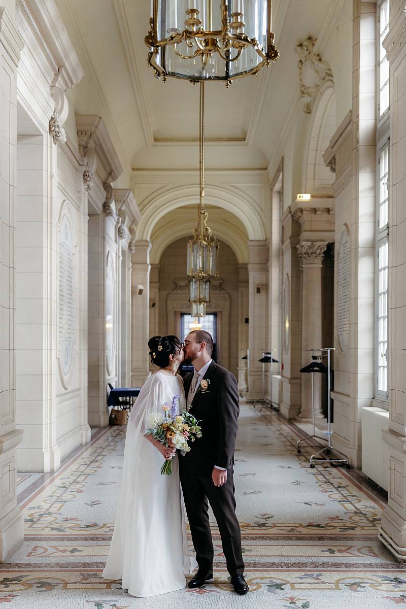 Les mariés s'embrassent avant d'entrer dans la salle des mariages.