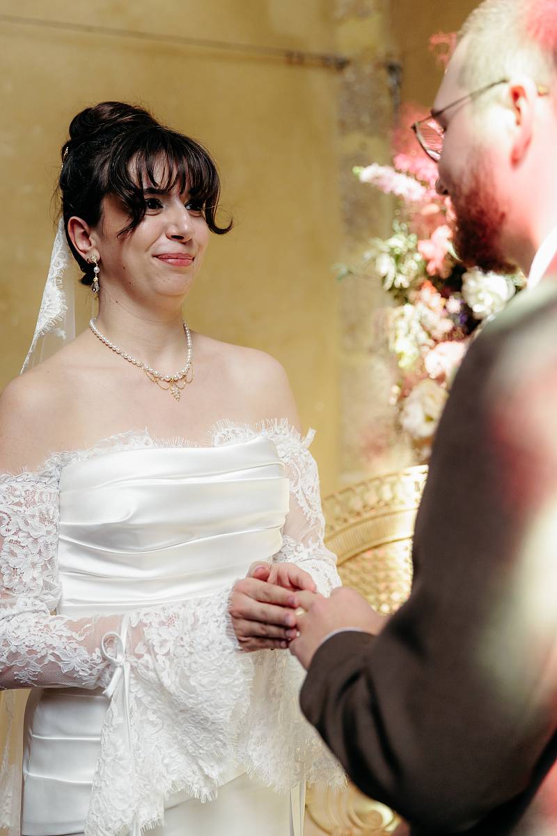 La mariée glisse l'alliance au doigt du marié.