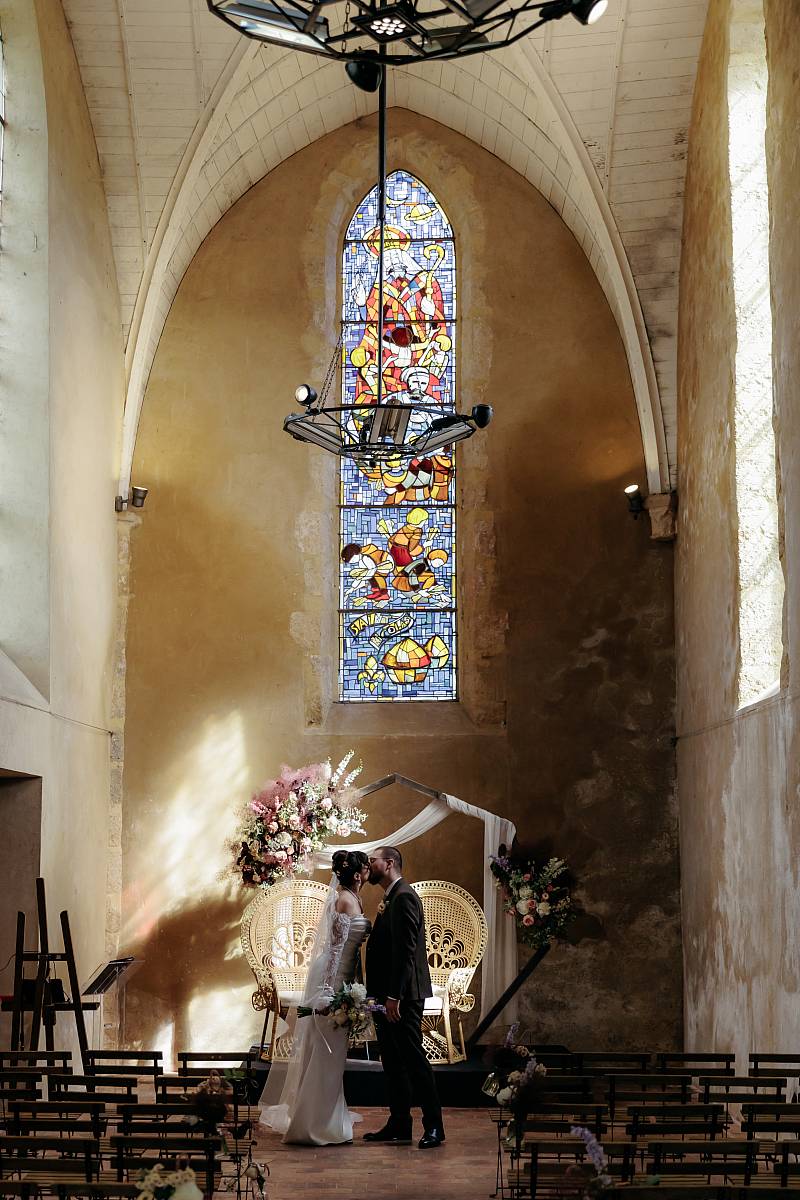 Portrait des mariés s'embrassant dans la chapelle Saint-Nicolas à Rennemoulin dans les Yvelines.