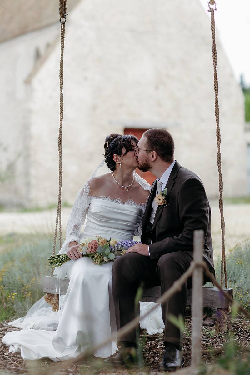Baiser des mariés sur une balançoire pendant la séance photo de couple.