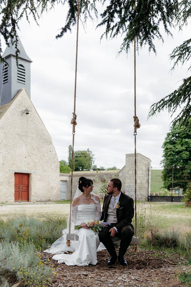 Les mariés sur une balançoire pendant la séance photo de couple.