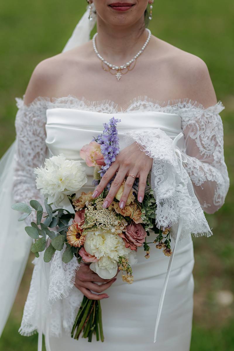 Gros plan sur la mariée et son bouquet.