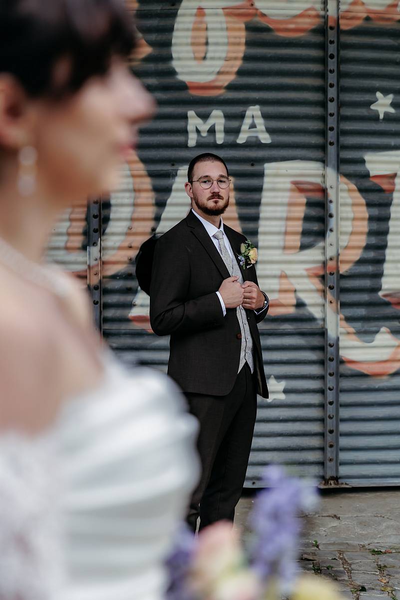 Portrait du marié avec la mariée en premier plan.