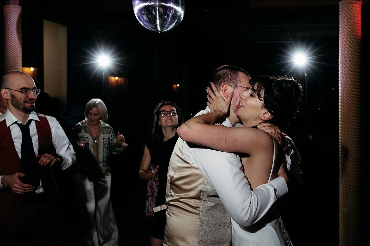 La mariée embrasse le marié pendant la soirée dansante.