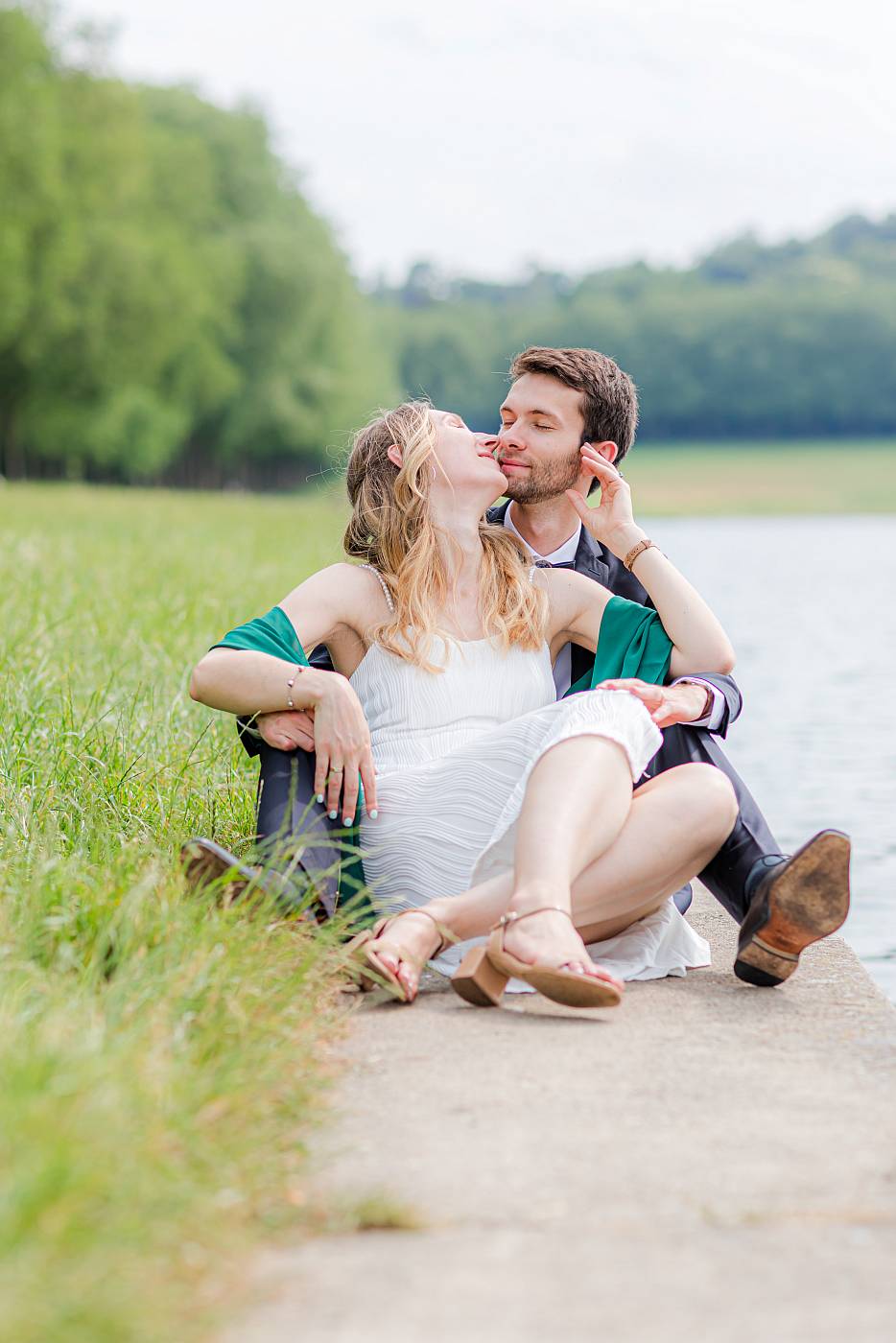 Les mariés assis sur les bords de la pièce d'eau des suisses pour les photos de couple