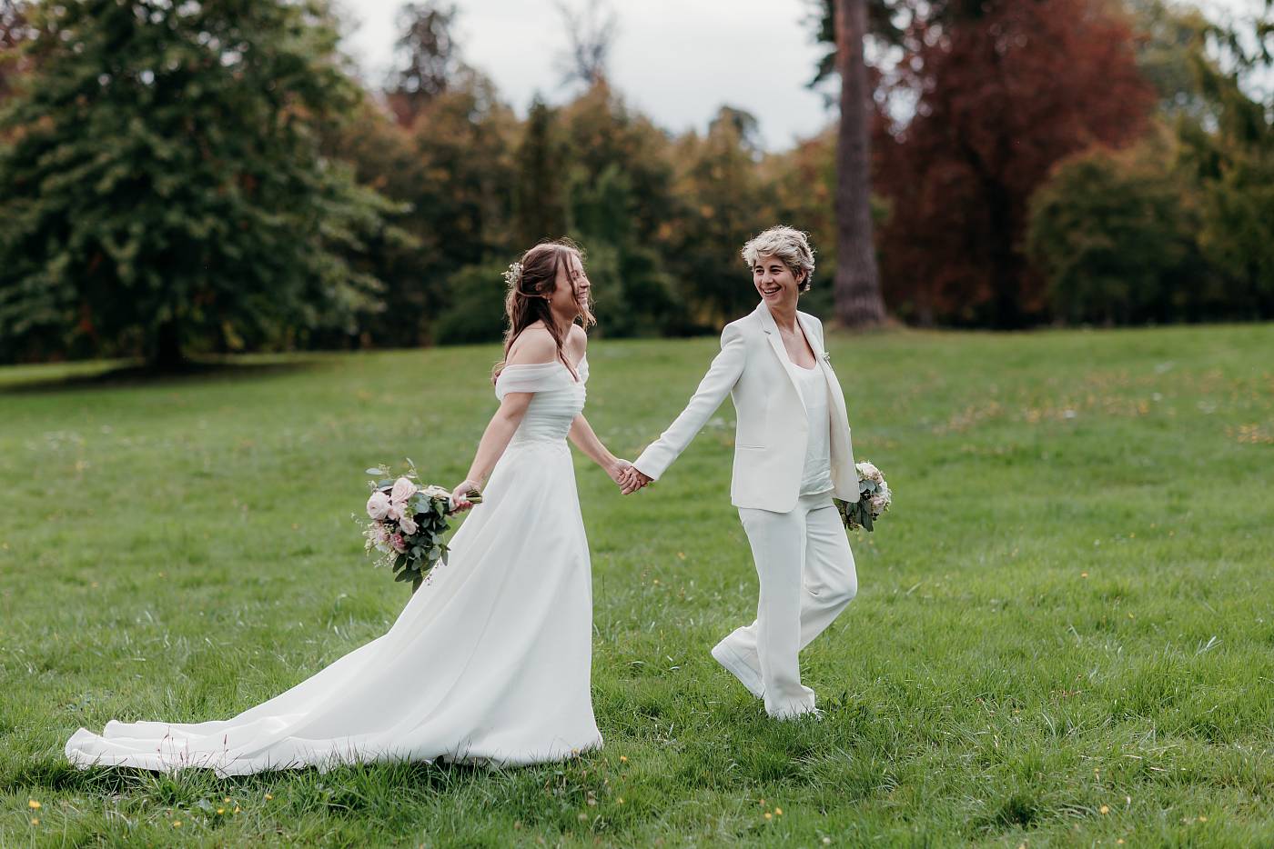 Les mariées marchent main dans la main dans la prairie à Versailles