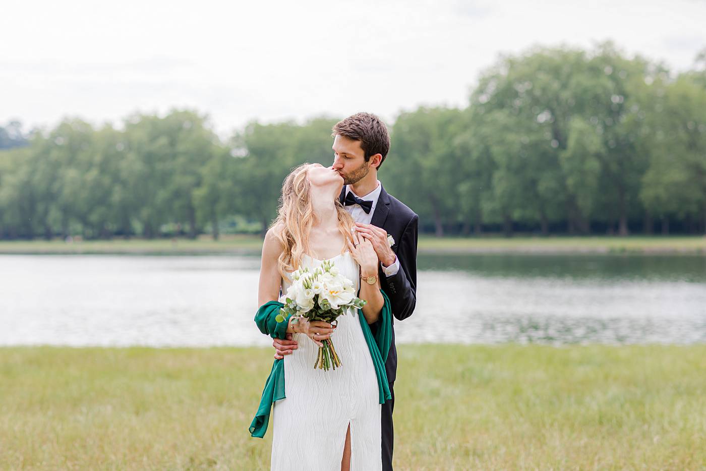 Le baiser des mariés enlacés devant la pièce d'eau des Suisses