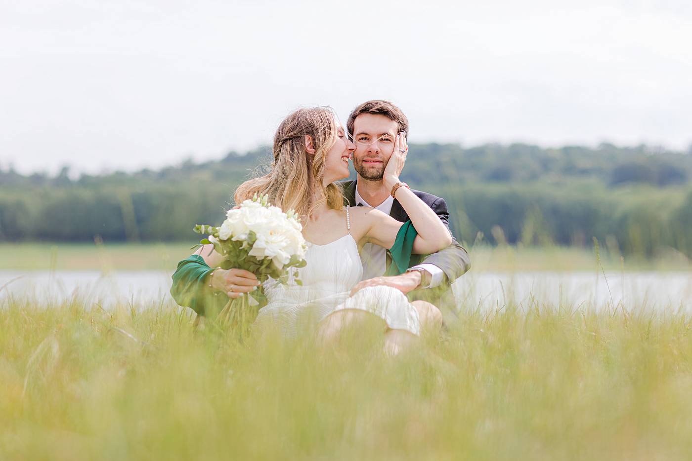 Les mariés allongés dans les hautes herbes en bordure de la pièce d'eau des Suisses